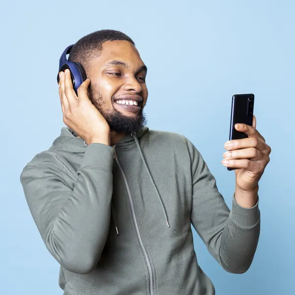 Rapaz de fone de ouvido sorrindo para o celular